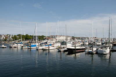 Boats moored at harbor against sky