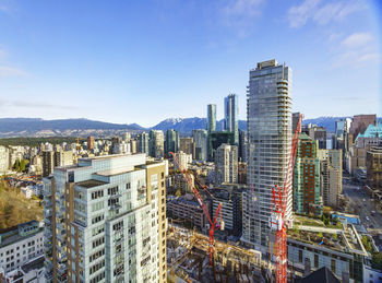 Aerial view of buildings in city against sky