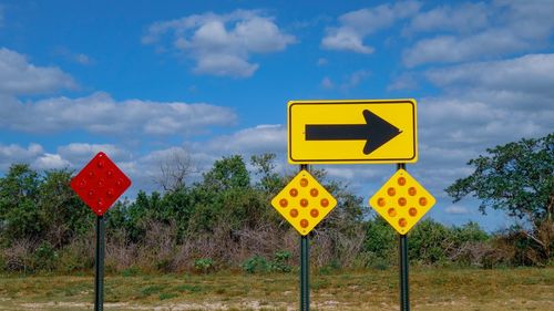 Road sign against sky