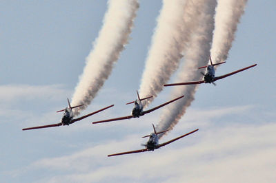 Low angle view of airplane flying against sky