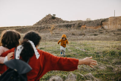 Cute girl coming towards mother at field