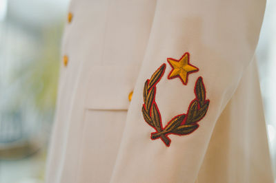 Midsection of person in uniform with logo