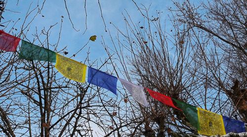 Low angle view of flags hanging against sky