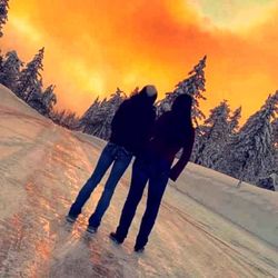 Rear view of two women walking on snow covered mountain