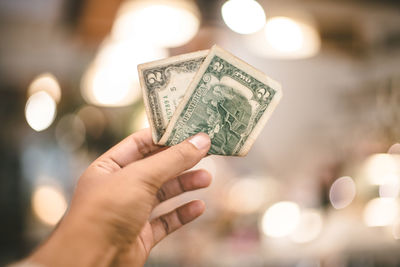 Close-up of hand holding illuminated lighting equipment
