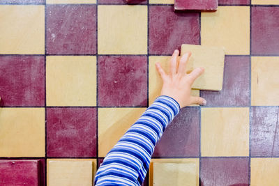 Low section of child on playing on tiled floor