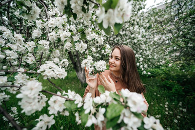 Beautiful young girl in the garden of blooming apple trees