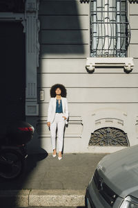 Young businesswoman leaning on wall