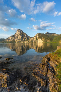 Scenic view of lake by mountain against sky