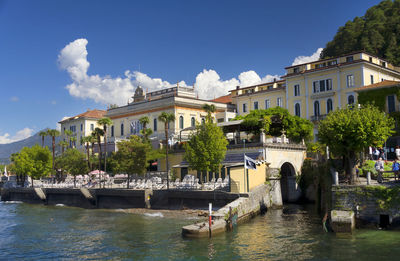 River with built structures against blue sky