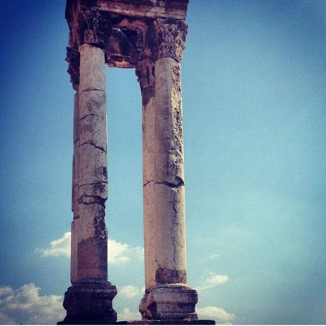 low angle view, blue, architectural column, column, architecture, built structure, history, sky, old, old ruin, clear sky, the past, weathered, sunlight, no people, day, outdoors, ancient, monument, building exterior