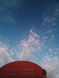 Low angle view of sign board against cloudy sky
