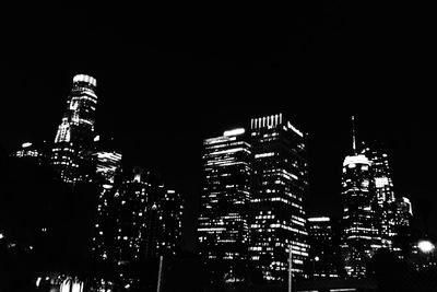 Low angle view of illuminated buildings against sky at night