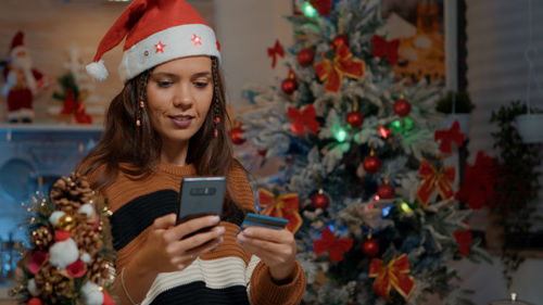 Young woman using mobile phone at home