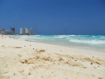 Scenic view of beach against clear blue sky