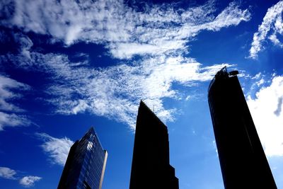 Low angle view of skyscrapers against blue sky