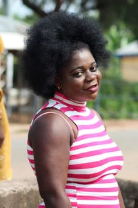 Portrait of woman with afro hair standing outdoors