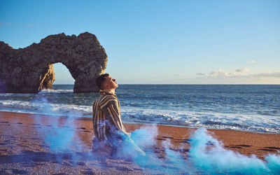 Young man by smoke at beach