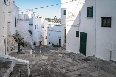 Houses by street in town against sky