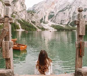 Rear view of woman on lake by mountains