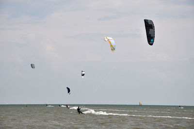 People in sea against sky