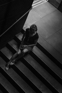 High angle view of woman sitting on staircase