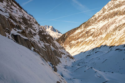 Scenic view of snow covered mountains against sky