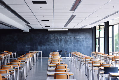 Empty chairs and tables in row at lecture room