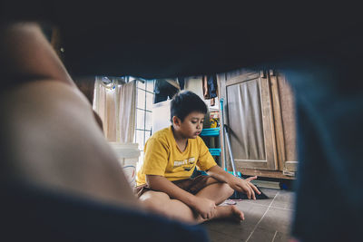 Boy sitting on floor at home