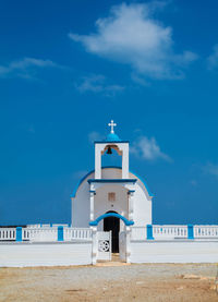 White greek orthodox church with blue roof in crete island, blue sky.