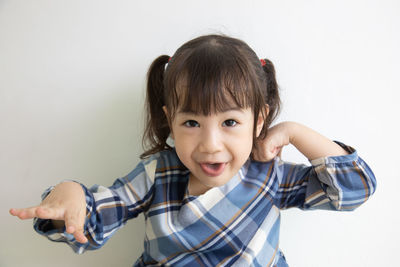 Portrait of cute girl standing against white background