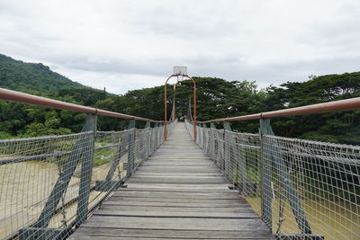 Rear view of woman walking on footbridge