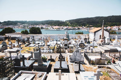 White graveyard by the sea against houses and mountains