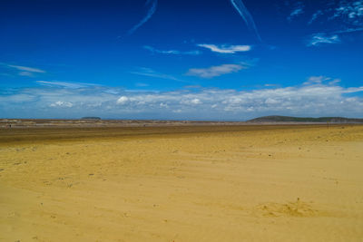 Scenic view of desert against blue sky