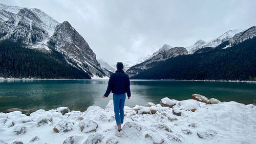 Rear view of woman walking on snow covered mountain