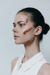 Close-up of young woman against white background