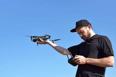 Portrait of man standing against clear blue sky