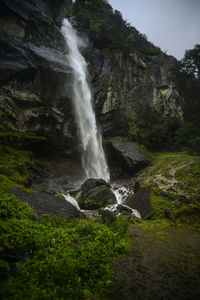 Scenic view of waterfall against sky