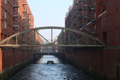 Bridge over river in city against clear sky
