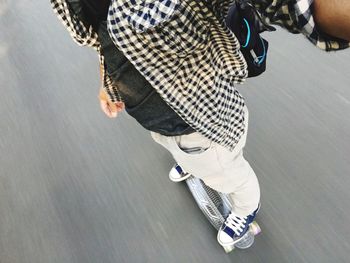 Low section of man skateboarding on road