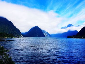 Scenic view of sea and mountains against sky