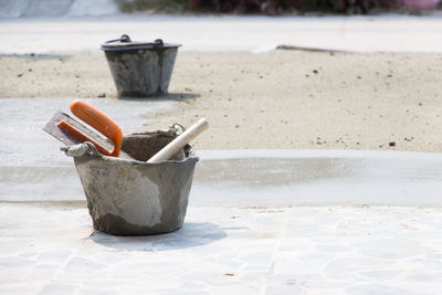 Close-up of trowel in bucket on footpath