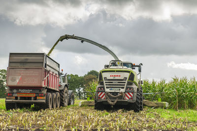 Tractor on agricultural field against sky