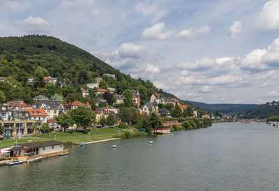 Scenic view of river by town against sky