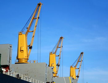 Low angle view of crane against blue sky