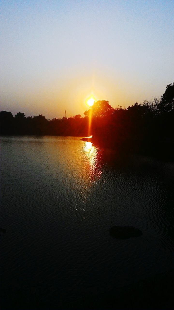 sunset, water, sun, reflection, tranquil scene, silhouette, scenics, tranquility, lake, beauty in nature, clear sky, nature, idyllic, sunlight, tree, sky, orange color, copy space, calm, outdoors