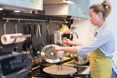 Side view of woman working in kitchen