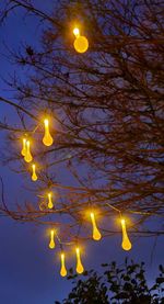 Low angle view of illuminated lamp against sky at night