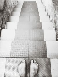 Low section of woman standing on staircase