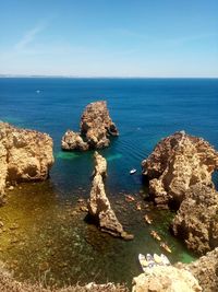 View of rocks in sea against sky